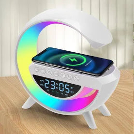 Multifunctional device with clock, Bluetooth speaker, and smartphone charging pad on a wooden surface.