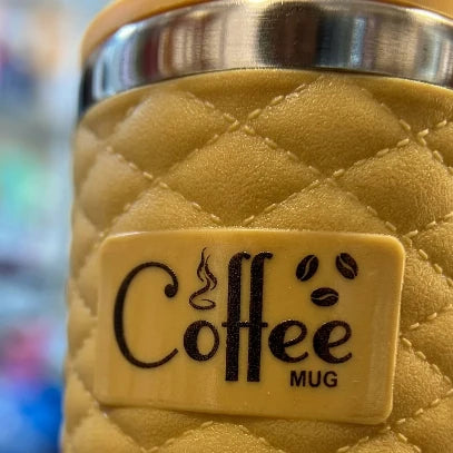 Quilted beige coffee mug with a 'Coffee Mug' label on a blurred background