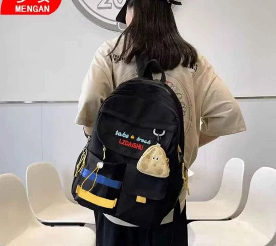 Person wearing a black backpack with cartoon designs in an indoor setting
