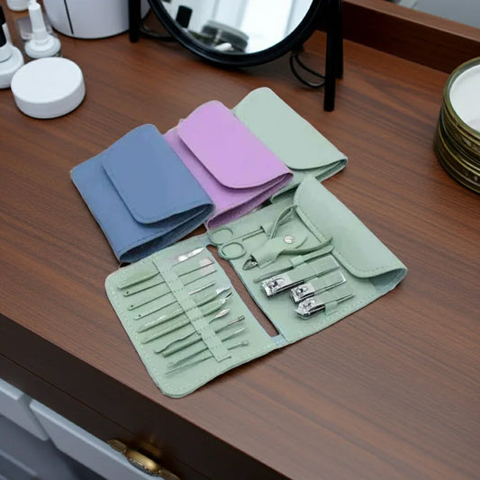 Set of nail care tools in a green case on a wooden surface