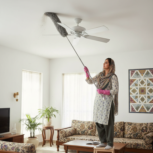 Person using telescopic microfiber fan duster to clean a ceiling fan in a Pakistani home