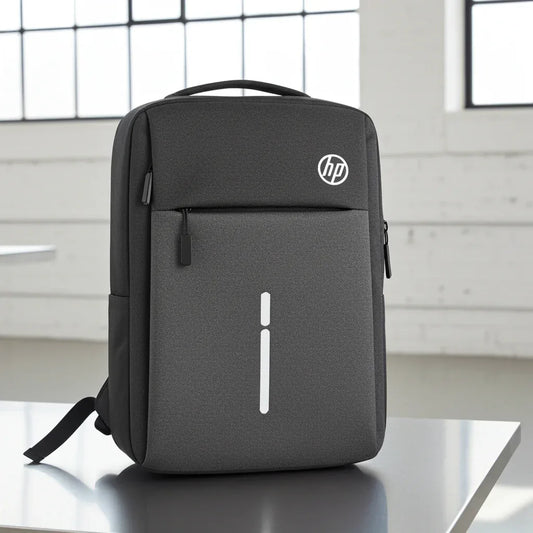 Gray HP backpack on a reflective surface with a blurred window background