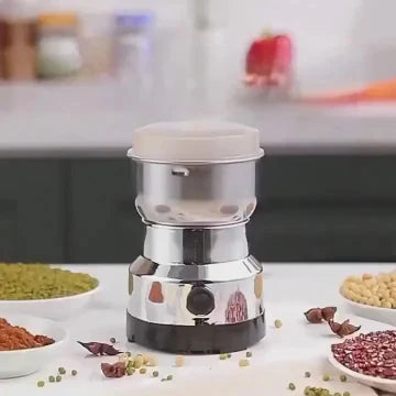 Spice grinder on a kitchen counter with various spices around