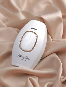 White electronic device with gold accents on a beige fabric background