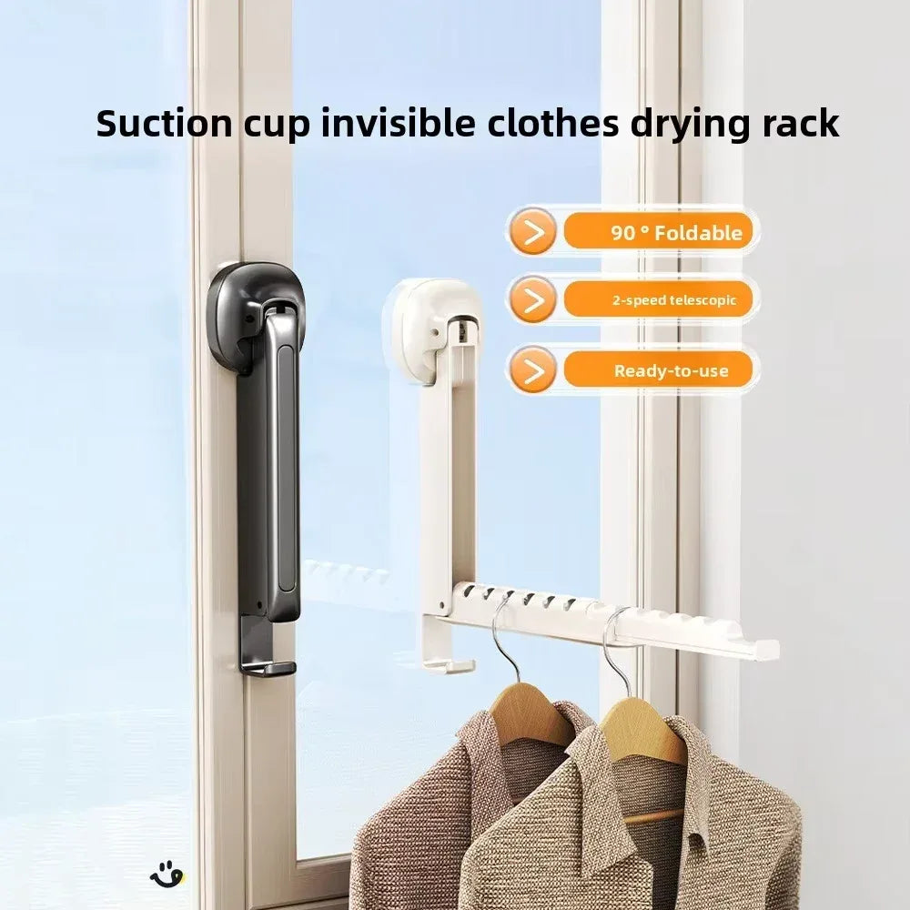Retractable folding wall-mounted clothes drying rack with suction cups installed on a bathroom tile wall, holding wet shirts.