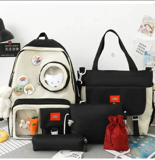Collection of bags including a backpack, black bag, and red drawstring bag on a light gray surface.