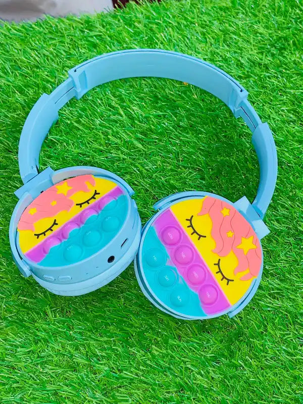 Children's headphones with colorful design on a grass background