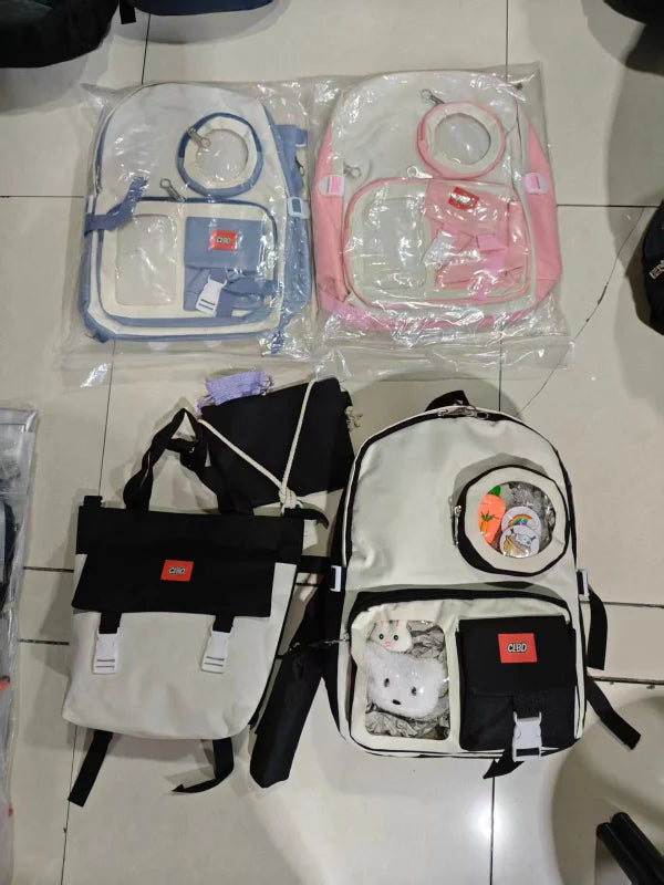 Collection of bags including a backpack and two smaller bags on a tiled floor.