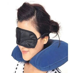 Woman wearing a blue travel pillow and black eye mask on a white background