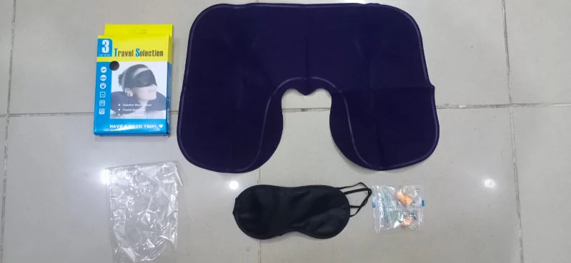 Travel set with eye mask, earplugs, and travel pillow on a tiled floor.