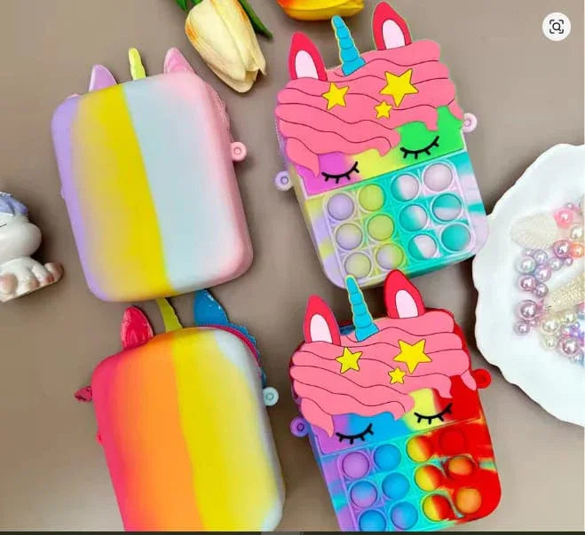 Colorful unicorn-themed phone cases with pop-it features on a brown surface.