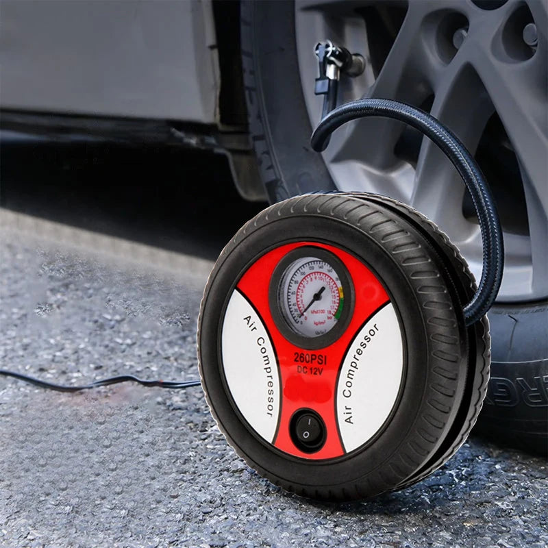 Car tire inflator with pressure gauge next to a car tire on a road.