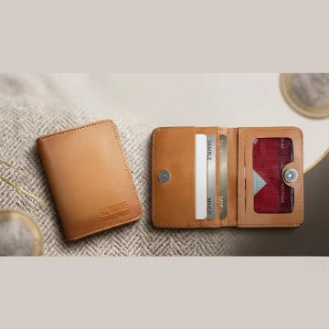 Brown leather wallet with card slots on a textured surface