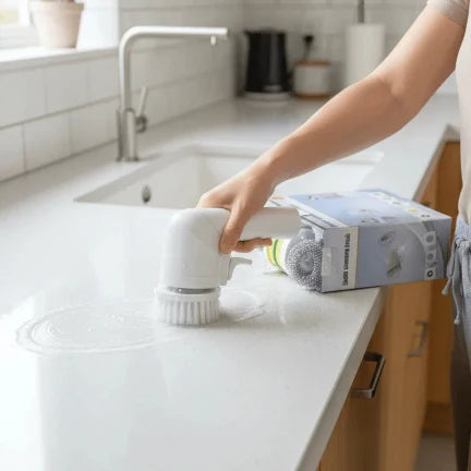 Person cleaning a kitchen counter with a handheld cleaning tool